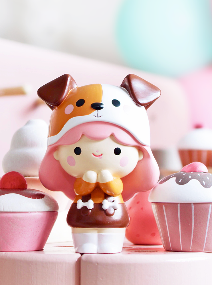 Momiji doll BFF with pink hair and a dog hat stands among pastel cupcakes and sweets, surrounded by kawaii details. — Momiji doll