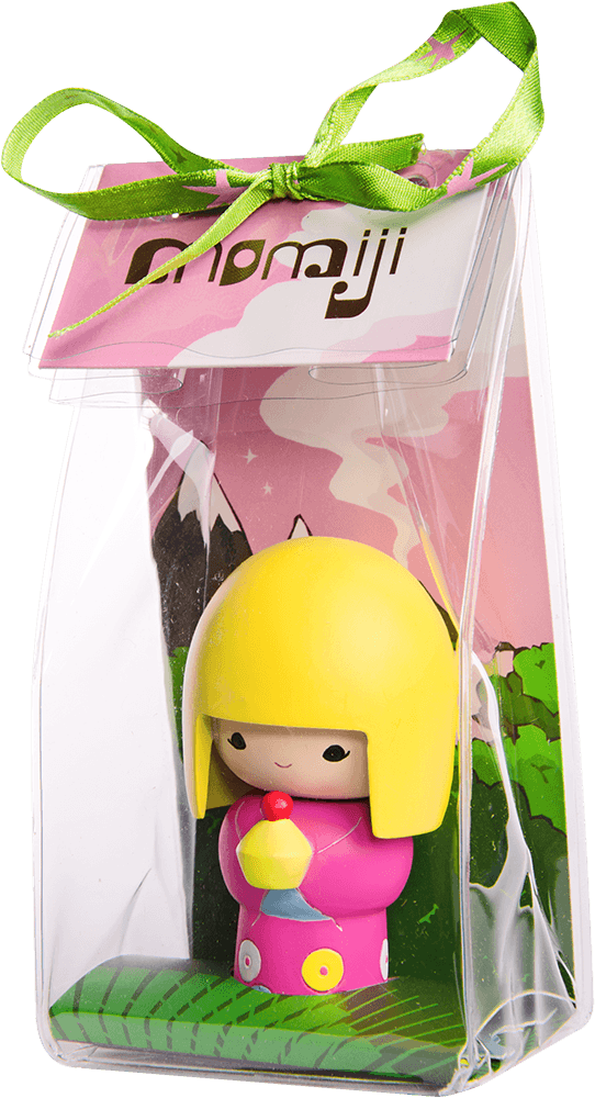 Pixie Momiji doll with yellow hair and pink outfit, in a clear bag tied with green ribbon, set against a colorful background. — Momiji doll