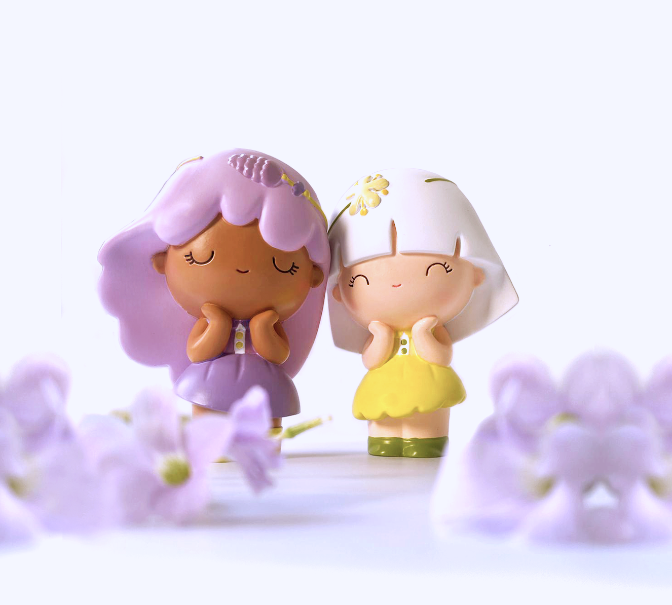 Two Linden Momiji dolls with pastel hair and dresses stand among soft purple flowers. Secret note inside each Momiji doll. — Momiji doll